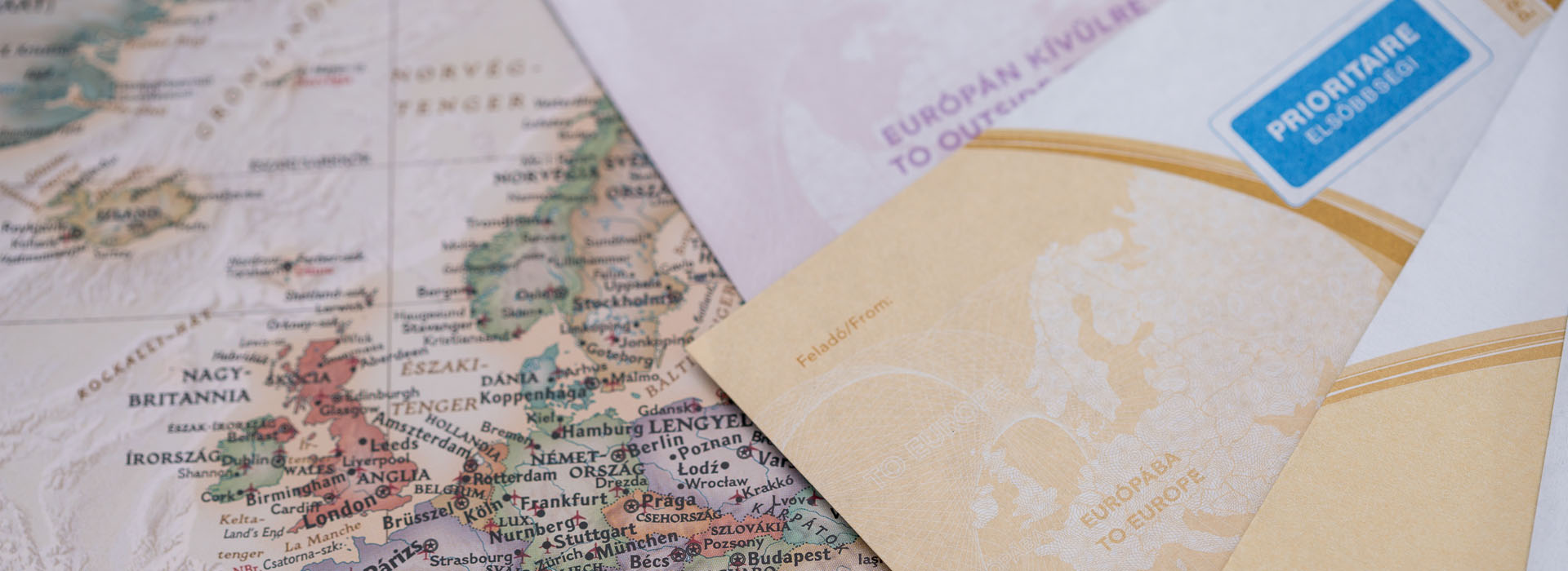 A képen nemzetközi postakész boríték látható és egy Európát ábrázoló térkép.